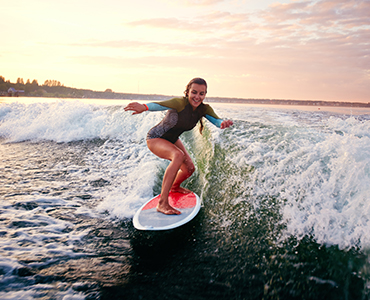 Australia - A man riding a wave on a surfboard in the water - Surfing